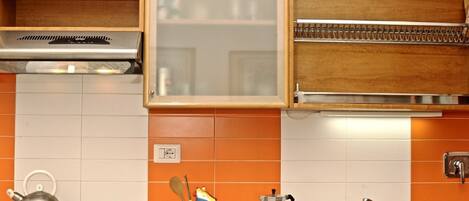 Eine Küche mit Gaskochfeld, Wasserkocher, Kaffeemaschine und Spüle.