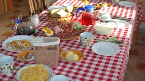 A table set for breakfast with various food items, utensils, and containers. - Guest House Koprivnik (Zrece)