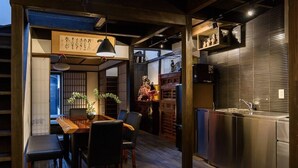 A modern kitchen with stainless steel appliances and a wooden dining area with a table and chairs. - Gojo Samurai Machiya, Gojo Samurai Machiya (Kyoto)