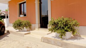 A building with a welcoming sign, a door, and potted plants. - B&B Shining (Avola)