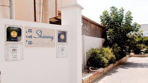 A building with multiple awards and certifications displayed on the wall, including a 9.8 rating from Booking.com and TripAdvisor. - B&B Shining (Avola)