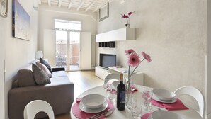 Una sala de estar moderna con un sofá, una mesa de comedor y un televisor.