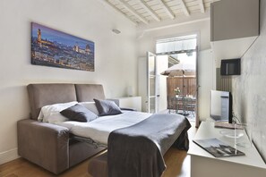 Quarto moderno com uma cama, uma escrivaninha e uma pintura com vista para a cidade.