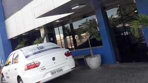A white car parked in front of a building with a sign that reads "HOTEL EXPRESS". - Hotel Express (Varzea Grande)