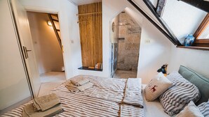 A bedroom with a bed, pillows, a bedside table, and a window. - Apartments Wanderlust (Bovec)