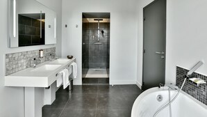 A modern bathroom with a large mirror, two sinks, a bathtub, and a shower. - Hôtel Joyet de Maubec (Uzerche)