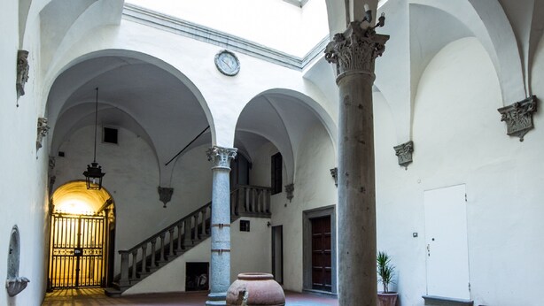 A spacious courtyard with arches, a large vase, and a staircase leading to an upper level. - Maggio View (Florence)