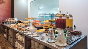 Un bufé con diferentes opciones de comida y una estación de bebidas.