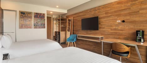 A hotel room with two beds, a desk, a chair, a TV, and a wardrobe.
