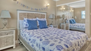 A bedroom with a bed, nightstands, a dresser, and a mirror. - RIGHT ON THE BEACH!!  Rockets and Cruise Ships! Kid and pet friendly, 2Br.   (Cocoa Beach)