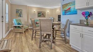 A dining area with a round table, wooden chairs, and a white cabinet. - RIGHT ON THE BEACH!!  Rockets and Cruise Ships! Kid and pet friendly, 2Br.   (Cocoa Beach)