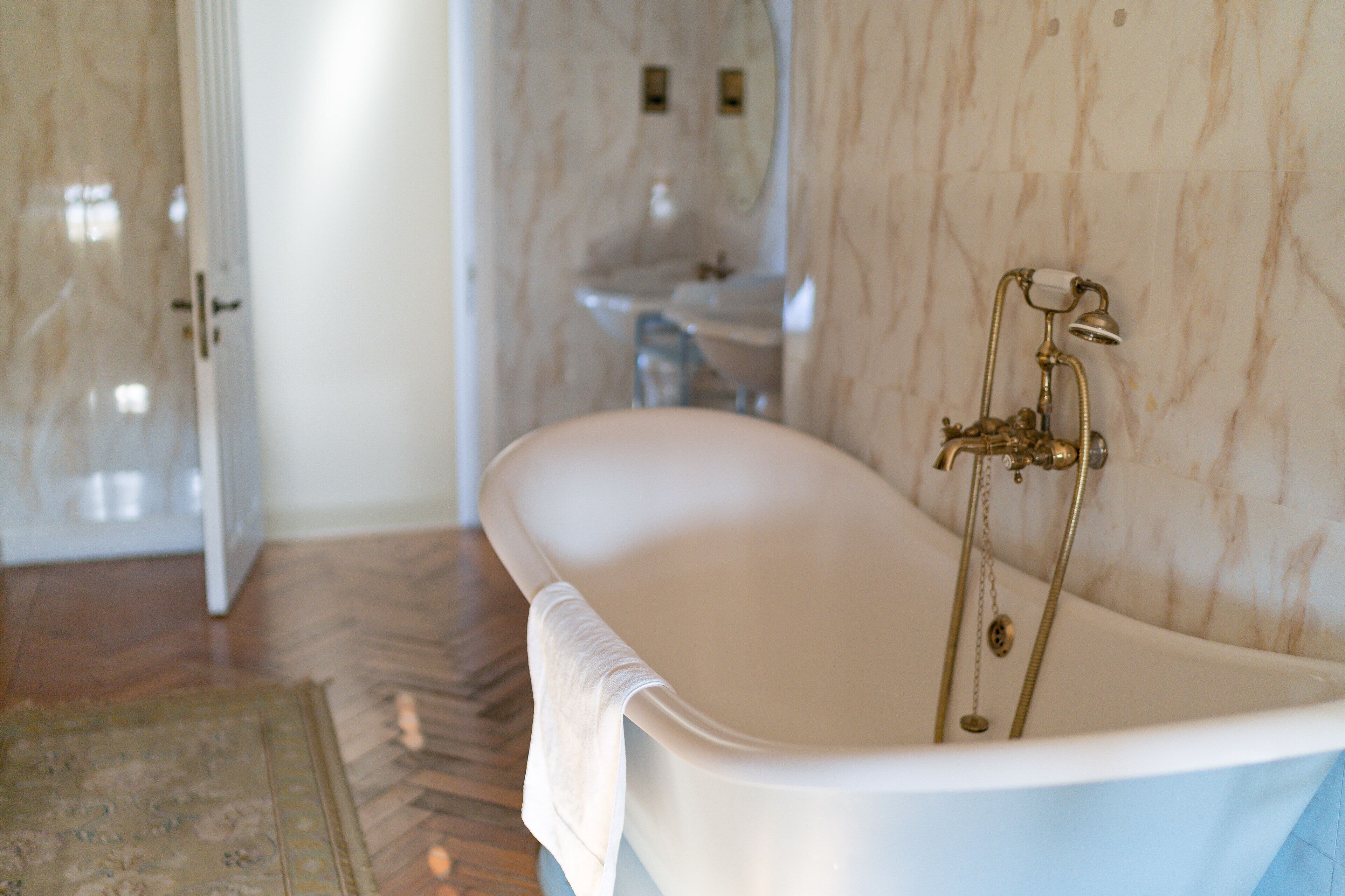 Bany amb banyera independent, un lavabo i un mirall.