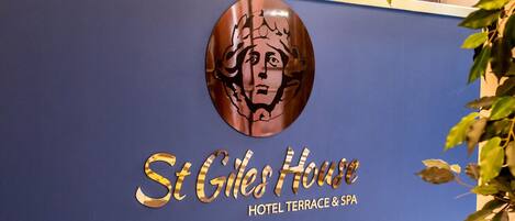 Una recepción con un logotipo y el nombre "St Giles House Hotel Terrace & Spa".