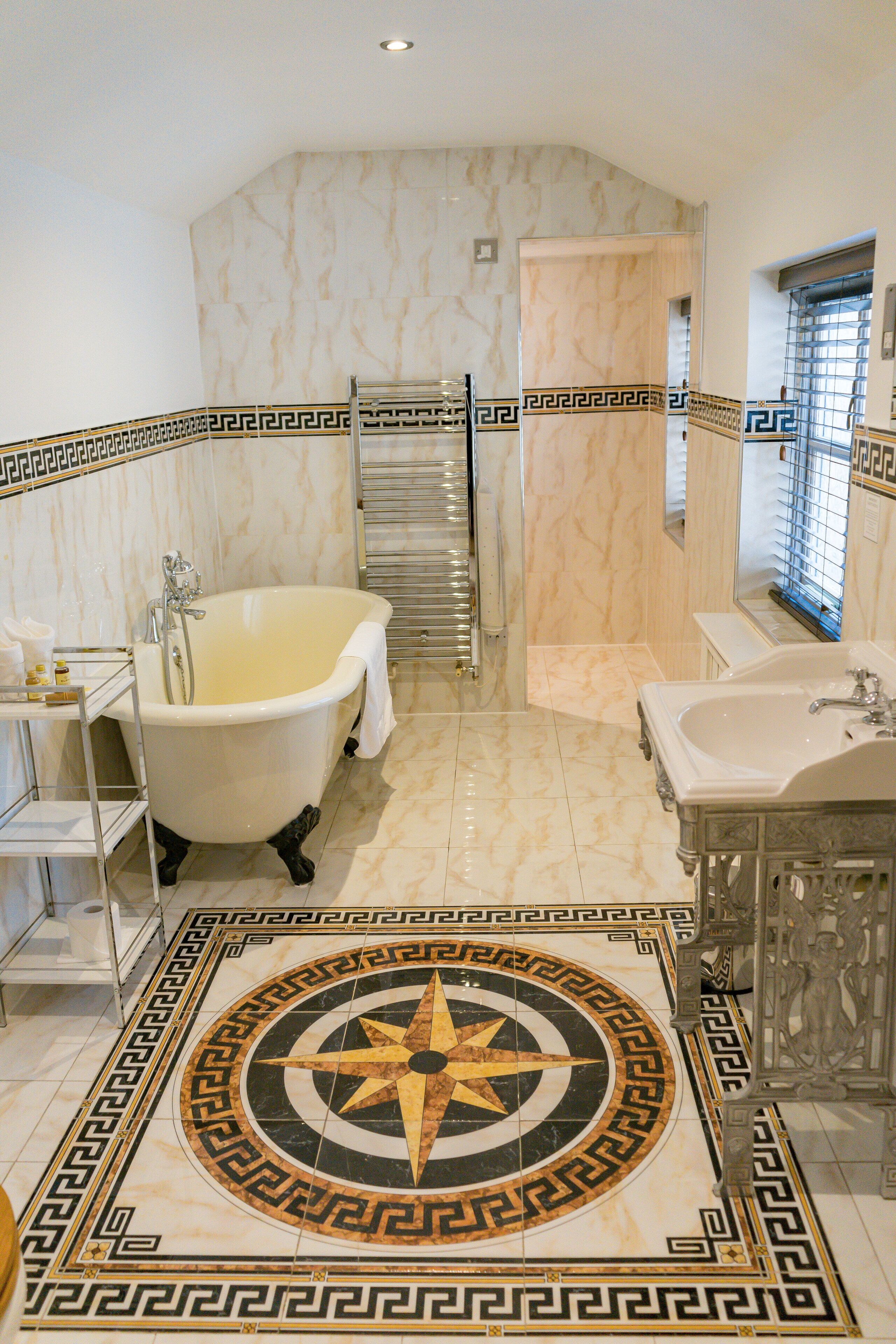 A bathroom with a freestanding bathtub, a sink, and a mirror.