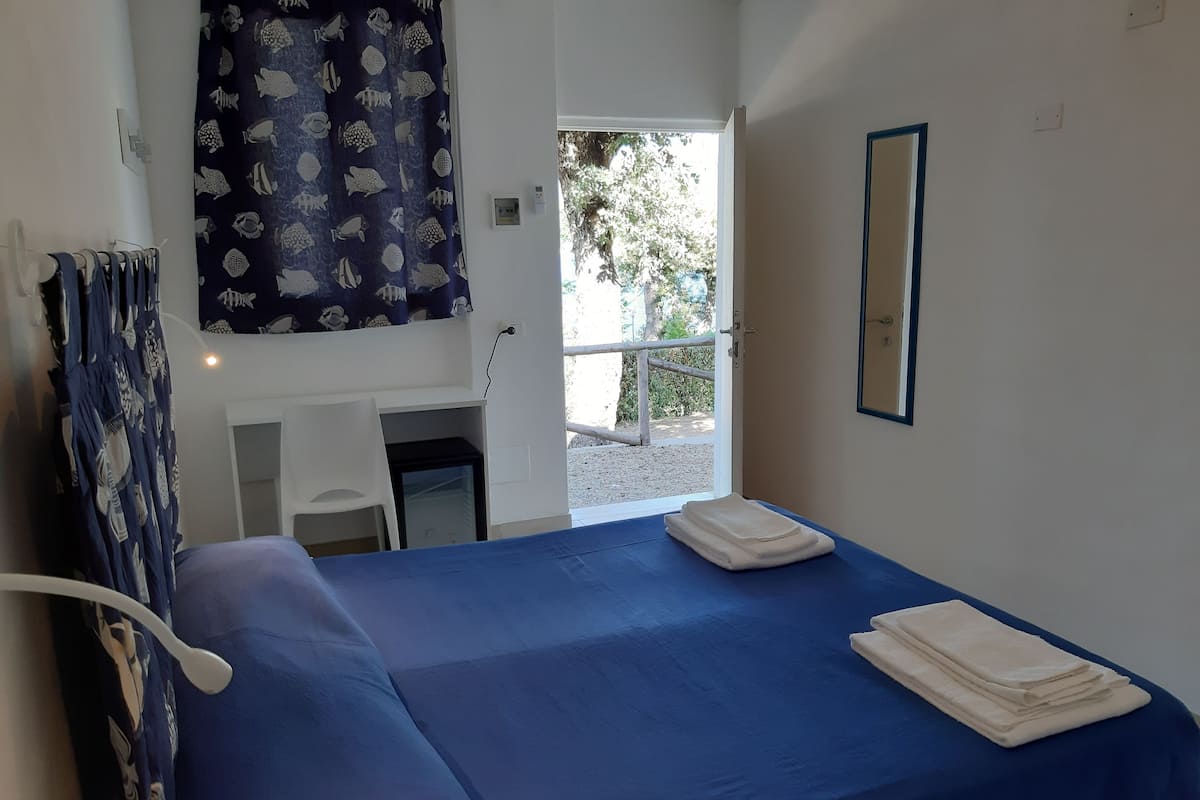Una habitación con una cama, un escritorio y una ventana.