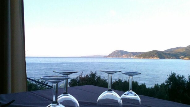 A table set for dining with a view of the sea and hills. - Hotel Grotte del Paradiso (Portoferraio)