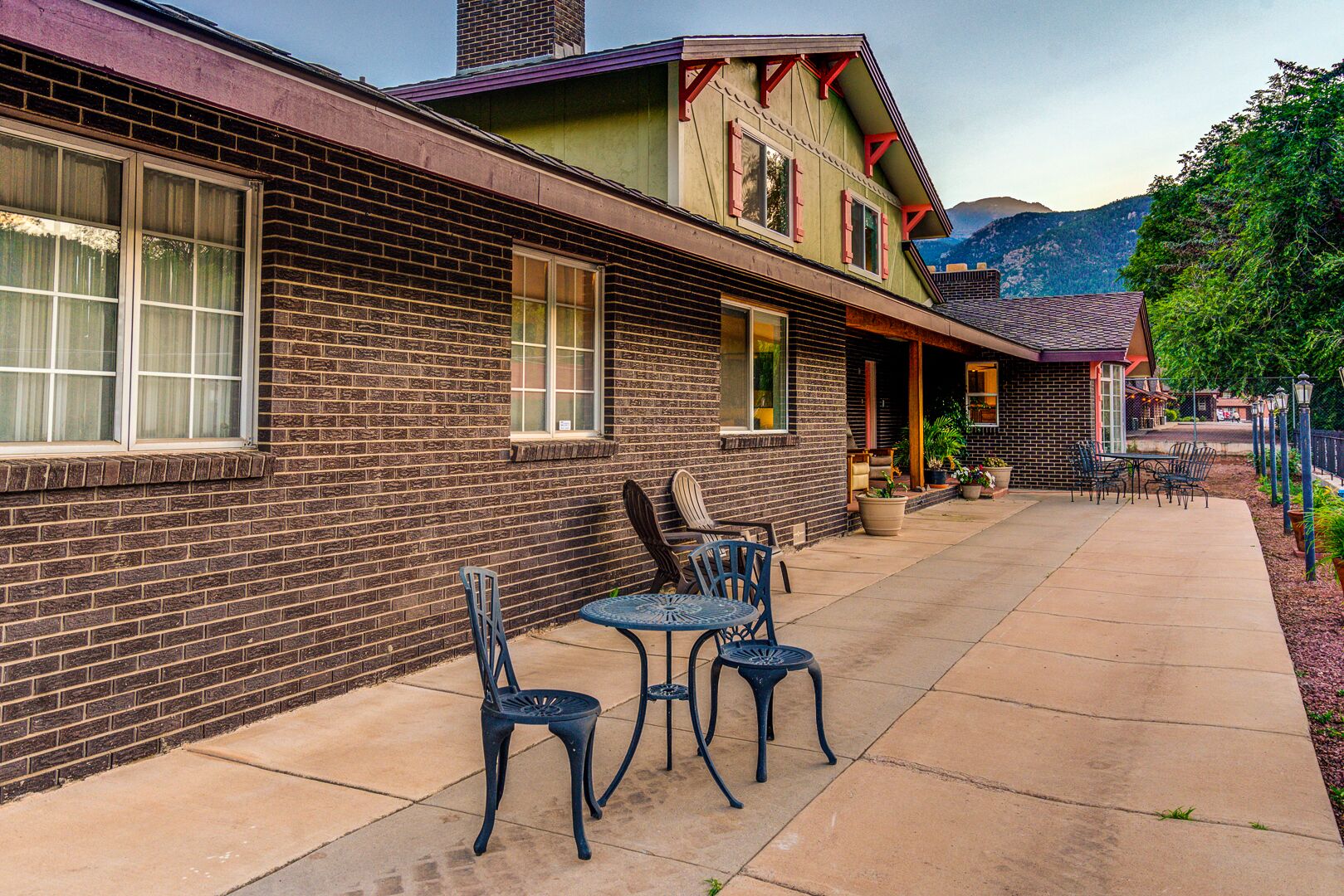 A two-story building with a brick facade and a covered patio area.