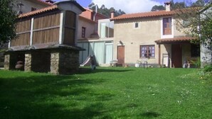 A traditional building with a stone foundation, a wooden balcony, and a red-tiled roof. - Casa Pousadoira (Mino)