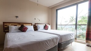 A hotel room with two beds, a large window with a view of palm trees, and a ceiling fan. - Mimosa Flat by Realty Group (Playa del Carmen)
