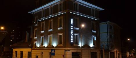A multi-story hotel with a prominent 'BEAUSTE HOTEL' sign, featuring a classic architectural style with large windows and a flat roof.
