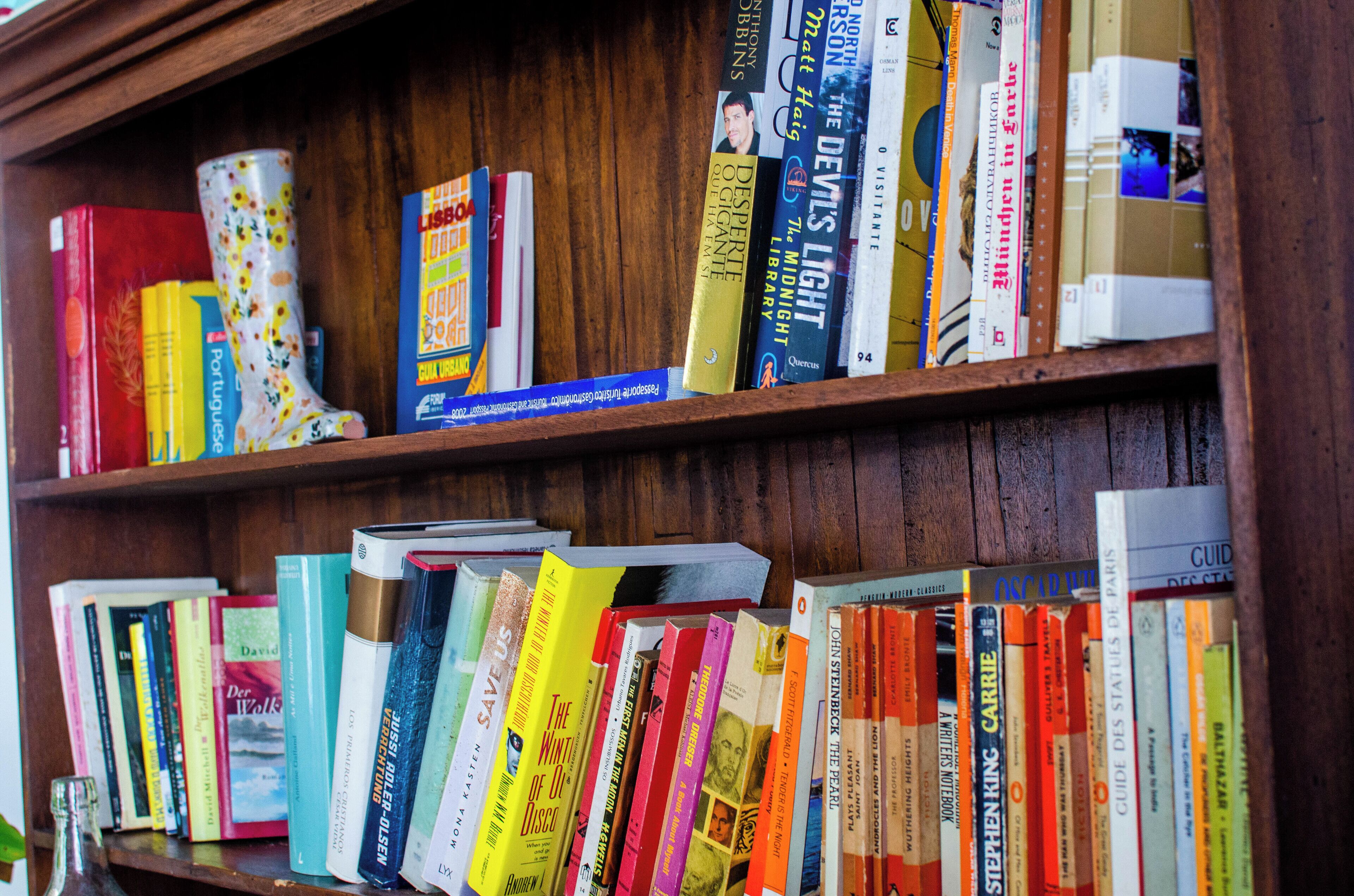 A wooden bookshelf filled with various books.