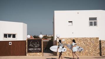 A building with a stone wall and a sign for 'Sagas Sun Stay'.