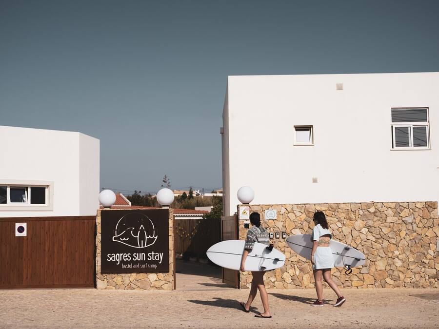 A building with a stone wall and a sign for 'Sagas Sun Stay'.