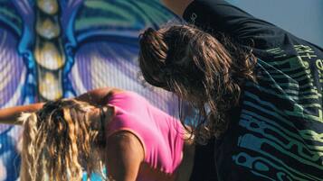 A person performing a yoga pose on a mat with a colorful mural in the background.