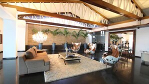 A spacious living area with a high ceiling, a large chandelier, and a modern sofa.