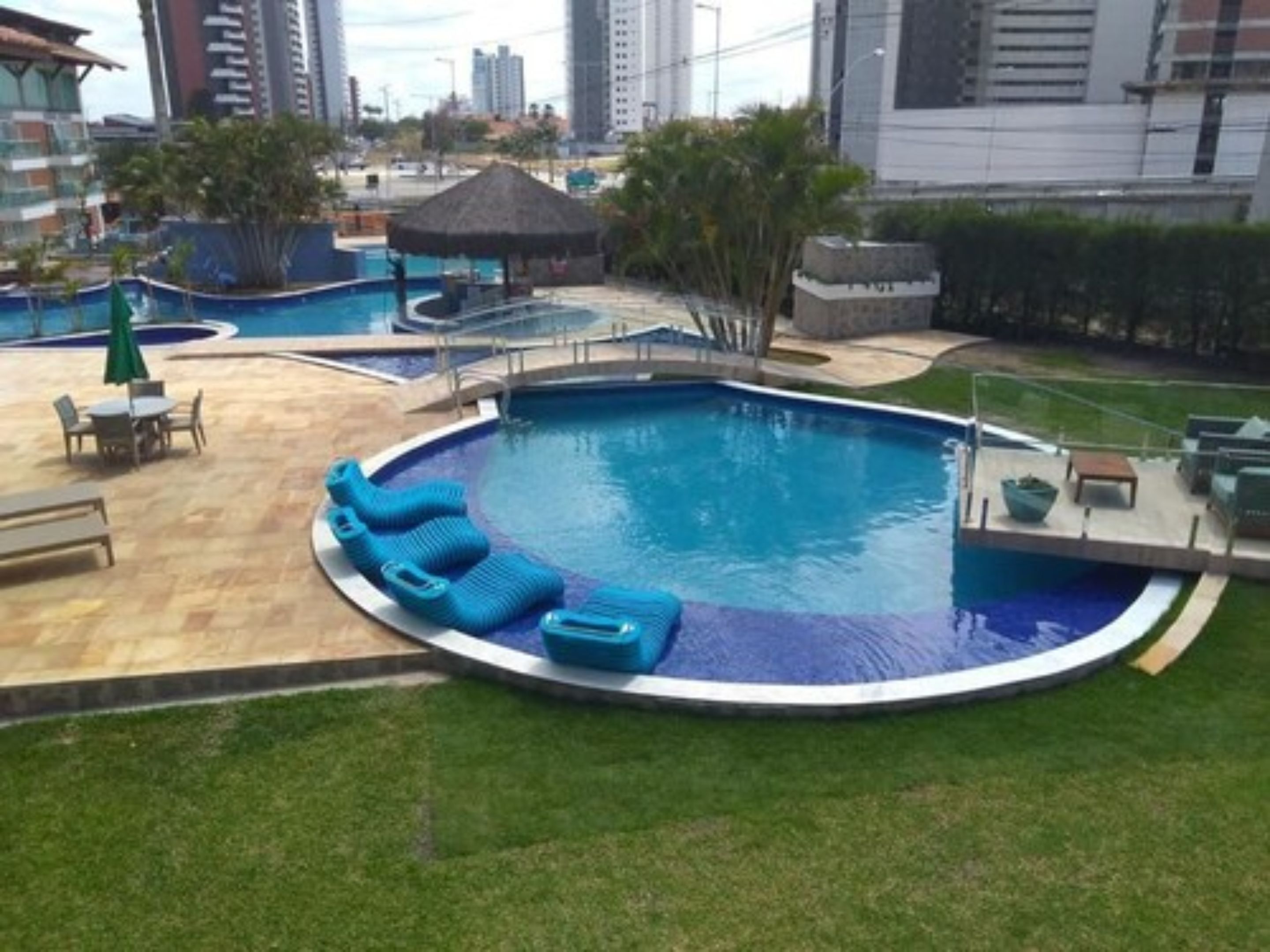 A swimming pool with lounge chairs and a small pavilion.