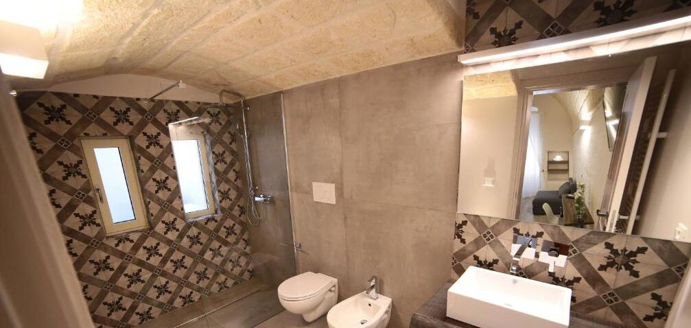 A bathroom with a shower, toilet, bidet, and sink.