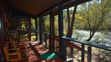 A wooden deck with a view of a lake and trees.