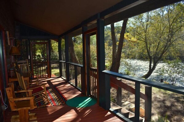 A wooden deck with a view of a lake and trees. - Rivers Edge (Mineral Bluff)