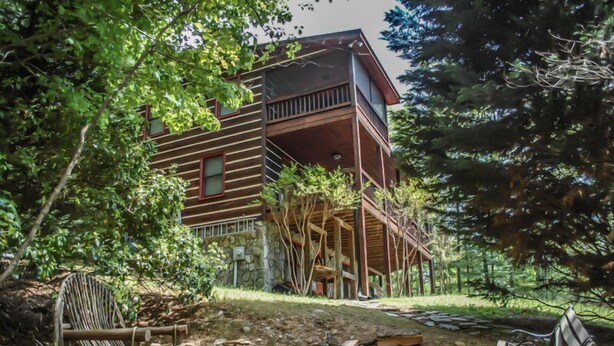 Eine Holzhütte mit Balkon und steinernen Fundamenten.
