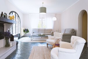Una sala de estar con sofá, sillones, una mesa de centro y una chimenea.