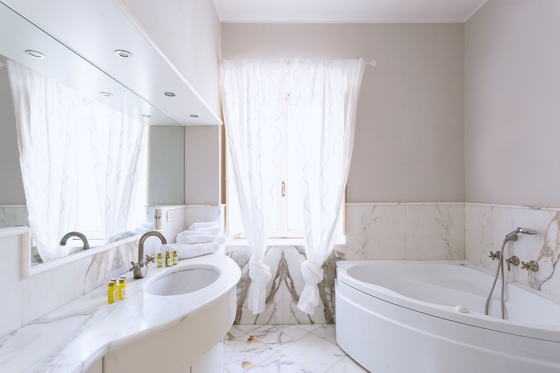 Un baño con una bañera grande, un lavabo doble y un espejo.