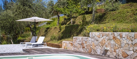 Una piscina al aire libre de temporada, sombrillas