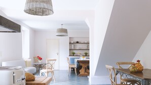 A modern kitchen with a dining area, featuring a wooden table, chairs, and a kitchen island. - Villa Borgovecchio B&B (Camaiore)
