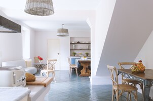 Una cocina moderna con zona de comedor, que incluye una mesa de madera, sillas y una isla de cocina.