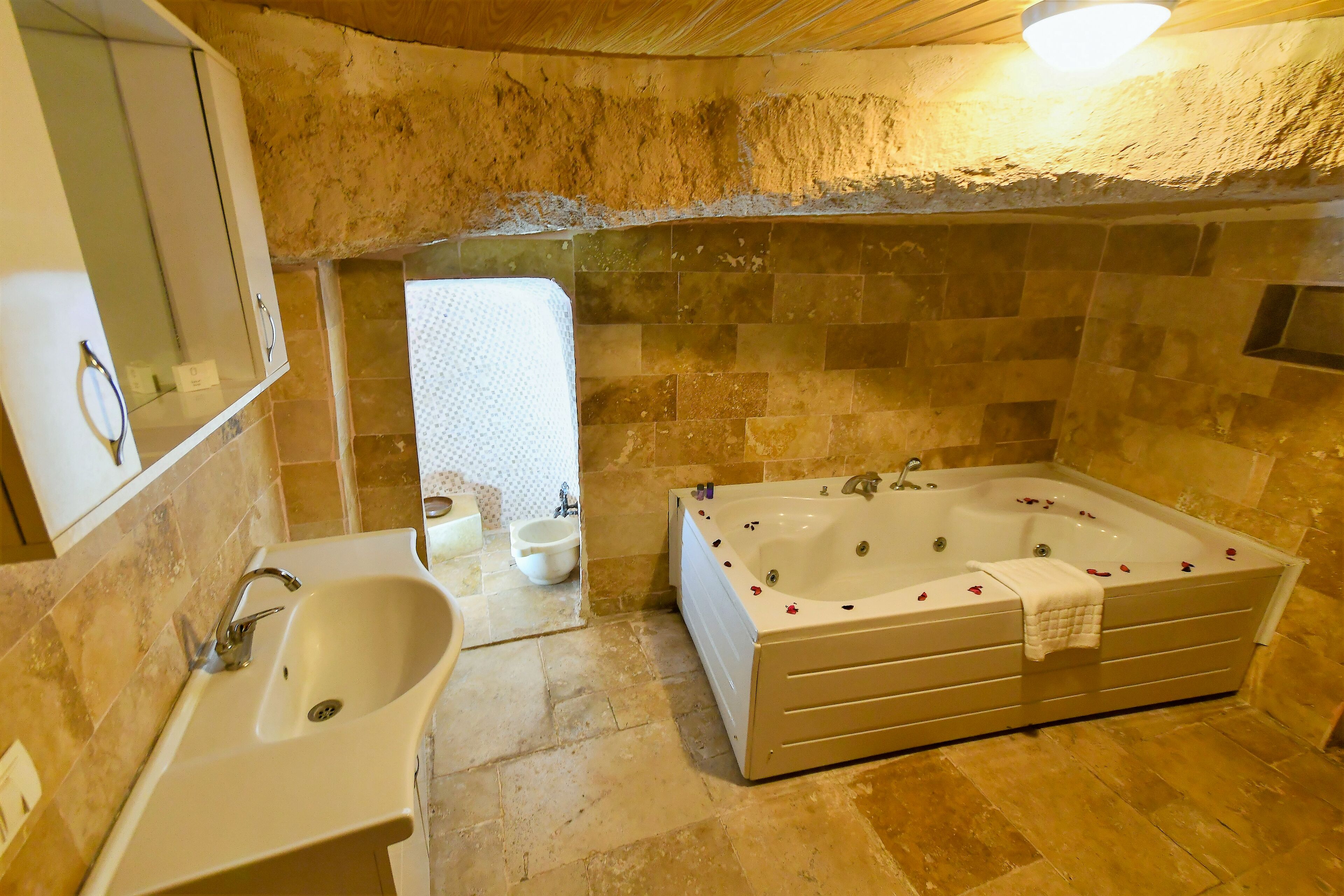 A bathroom with a bathtub, sink, and mirror.