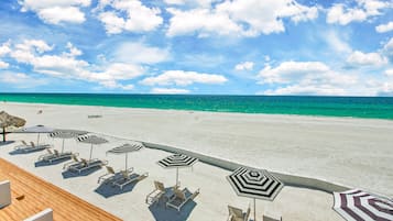 Am Strand, weißer Sandstrand, Liegestühle, Sonnenschirme
