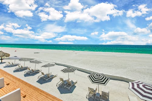 On the beach, white sand, sun-loungers, beach umbrellas