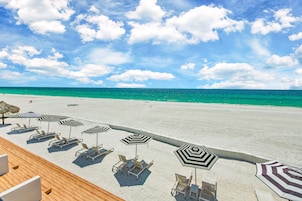 On the beach, white sand, sun-loungers, beach umbrellas
