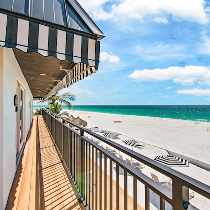 A balcony with a view of a beach and ocean.