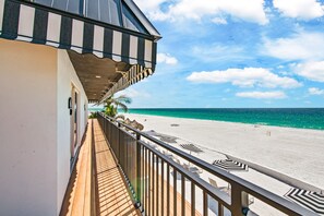 A balcony with a view of a beach and ocean.