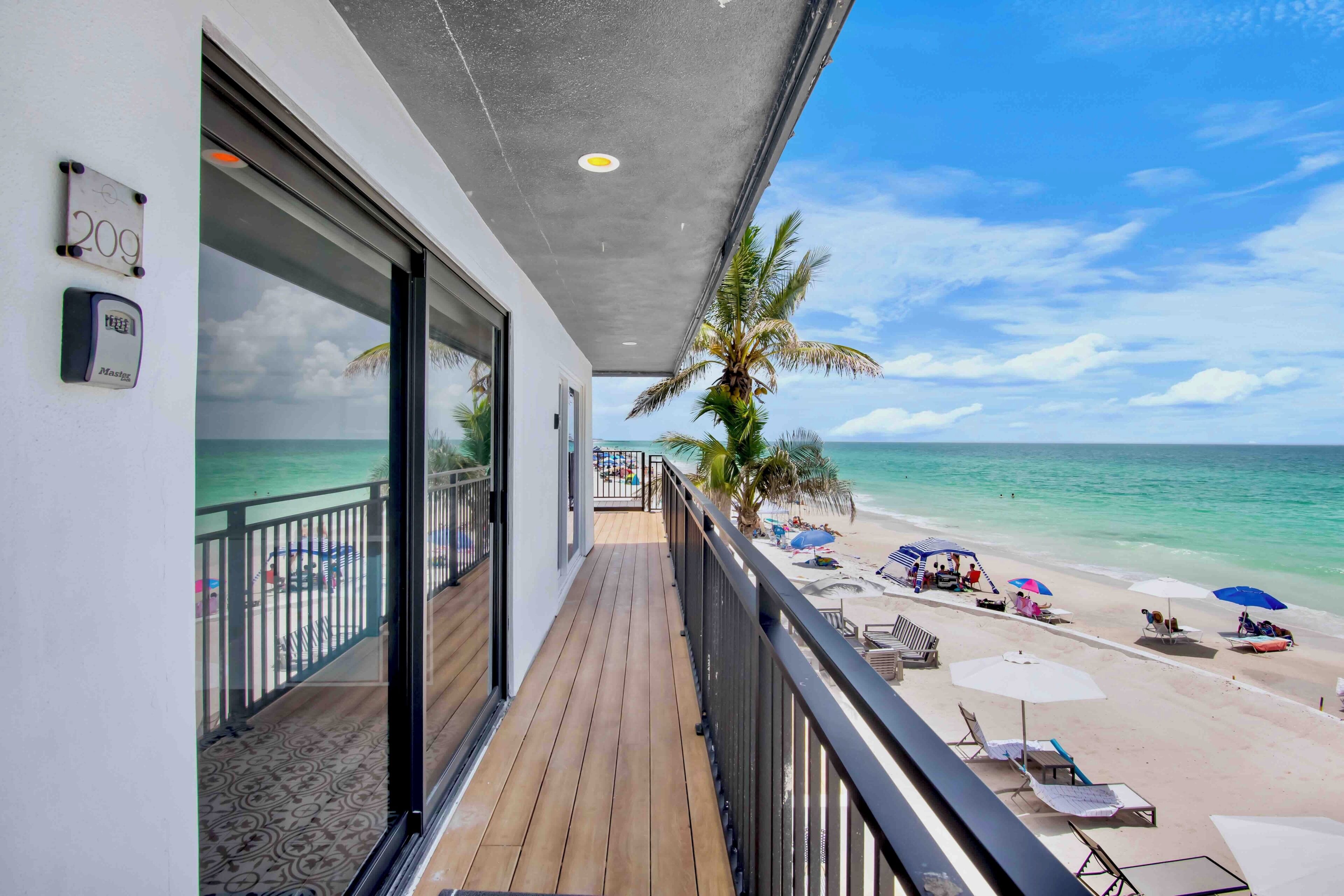 Een balkon met uitzicht op een strand en de oceaan.