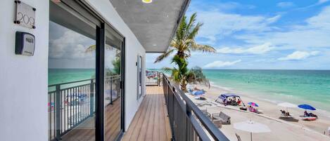 A balcony with a view of a beach and ocean.