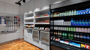 A modern retail space with refrigerated display cases and shelves stocked with beverages and snacks.