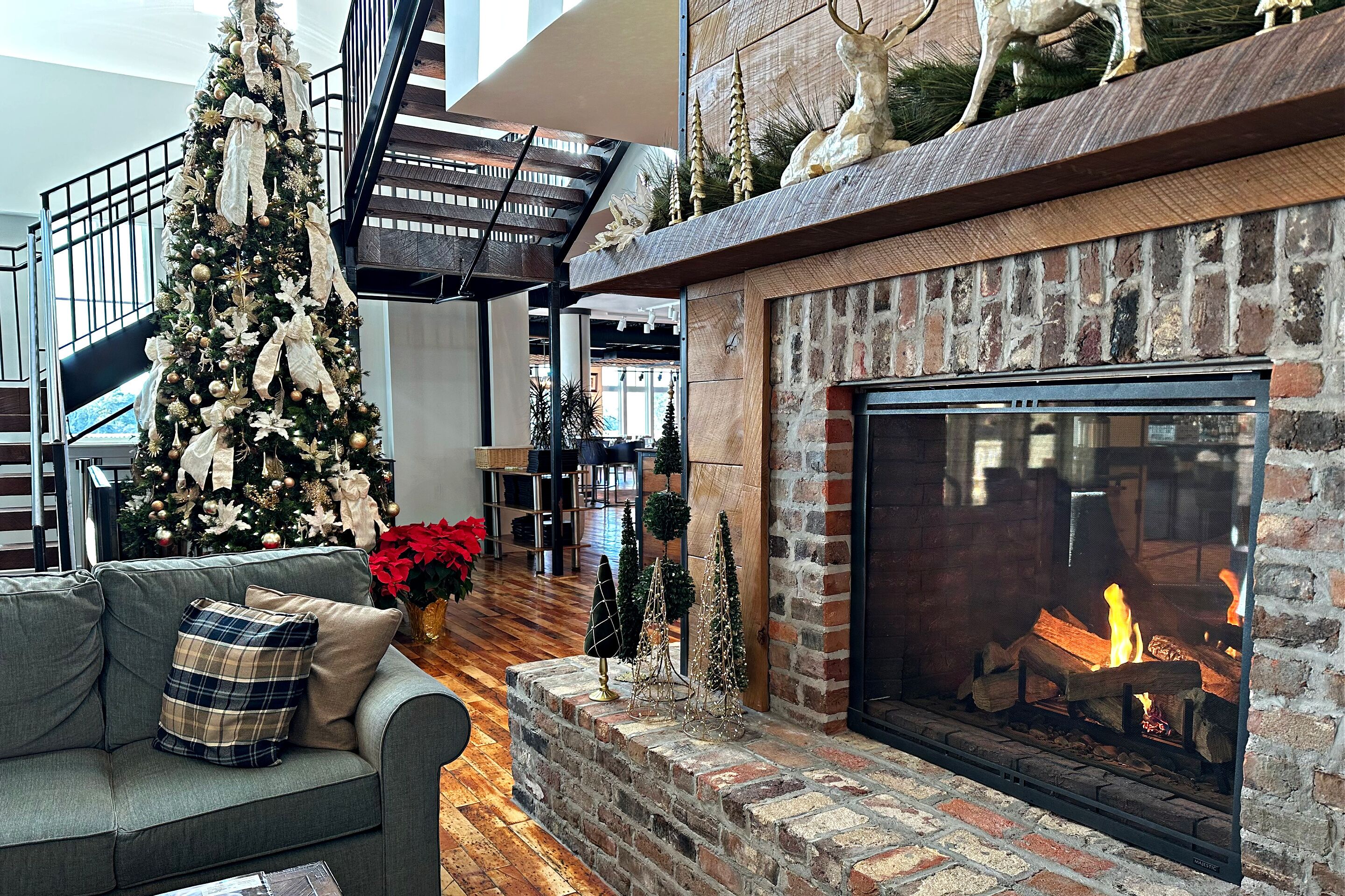 Un espacio de sala acogedor con chimenea, un árbol de Navidad y una escalera.