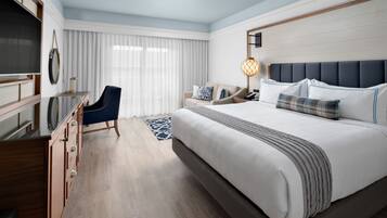 A modern hotel room with a large bed, a desk, and a chair.